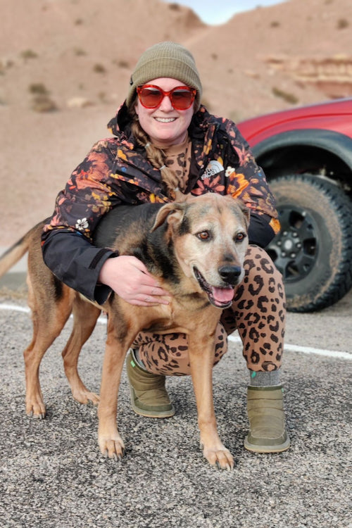 Ali is posing (sort of) with her German Shepherd mix dog, Maggie. Maggie is busy exploring, so she's trying to get away.